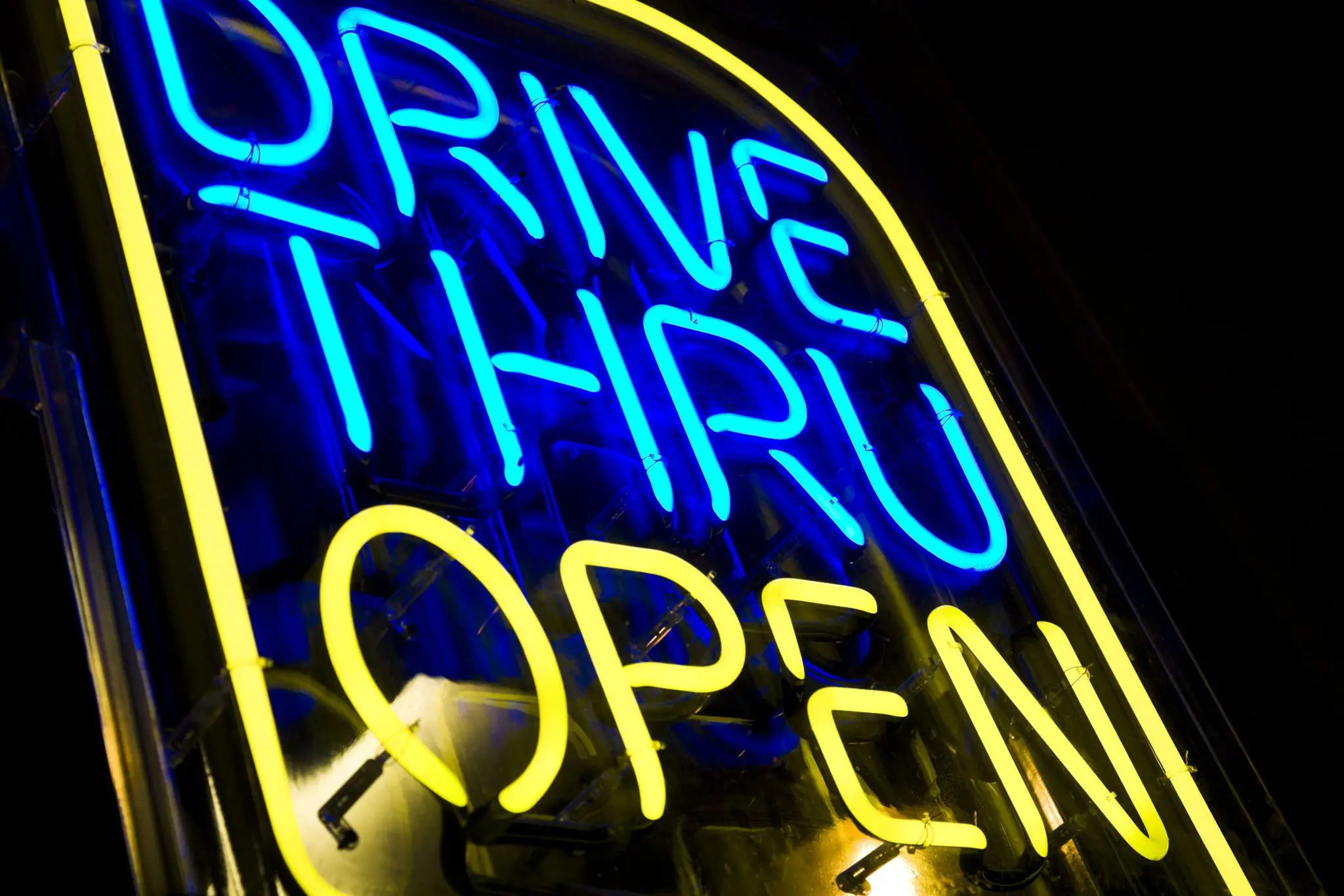Blue and yellow drive-thru neon open sign
