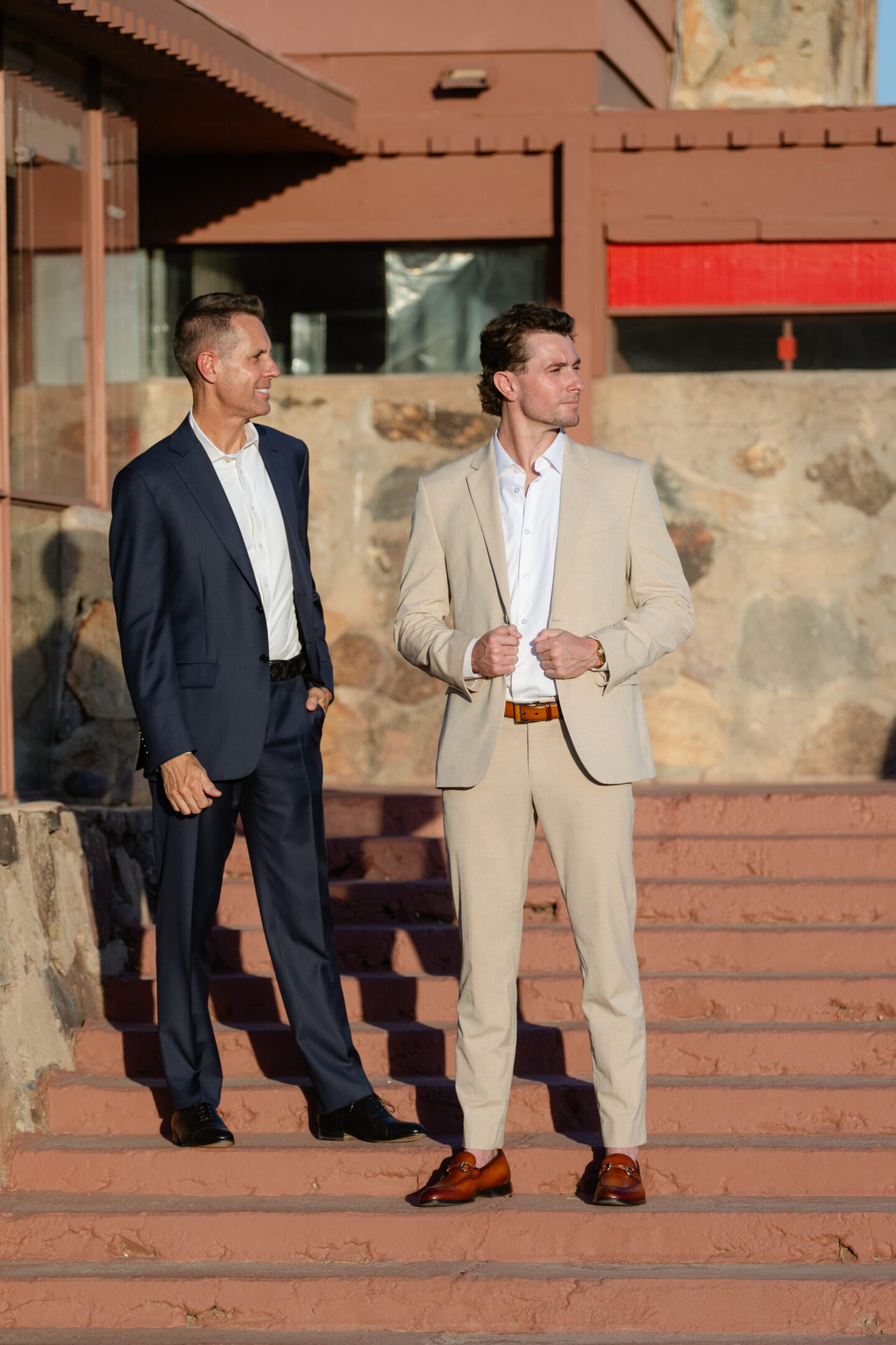 Two men in suits on sunlit steps