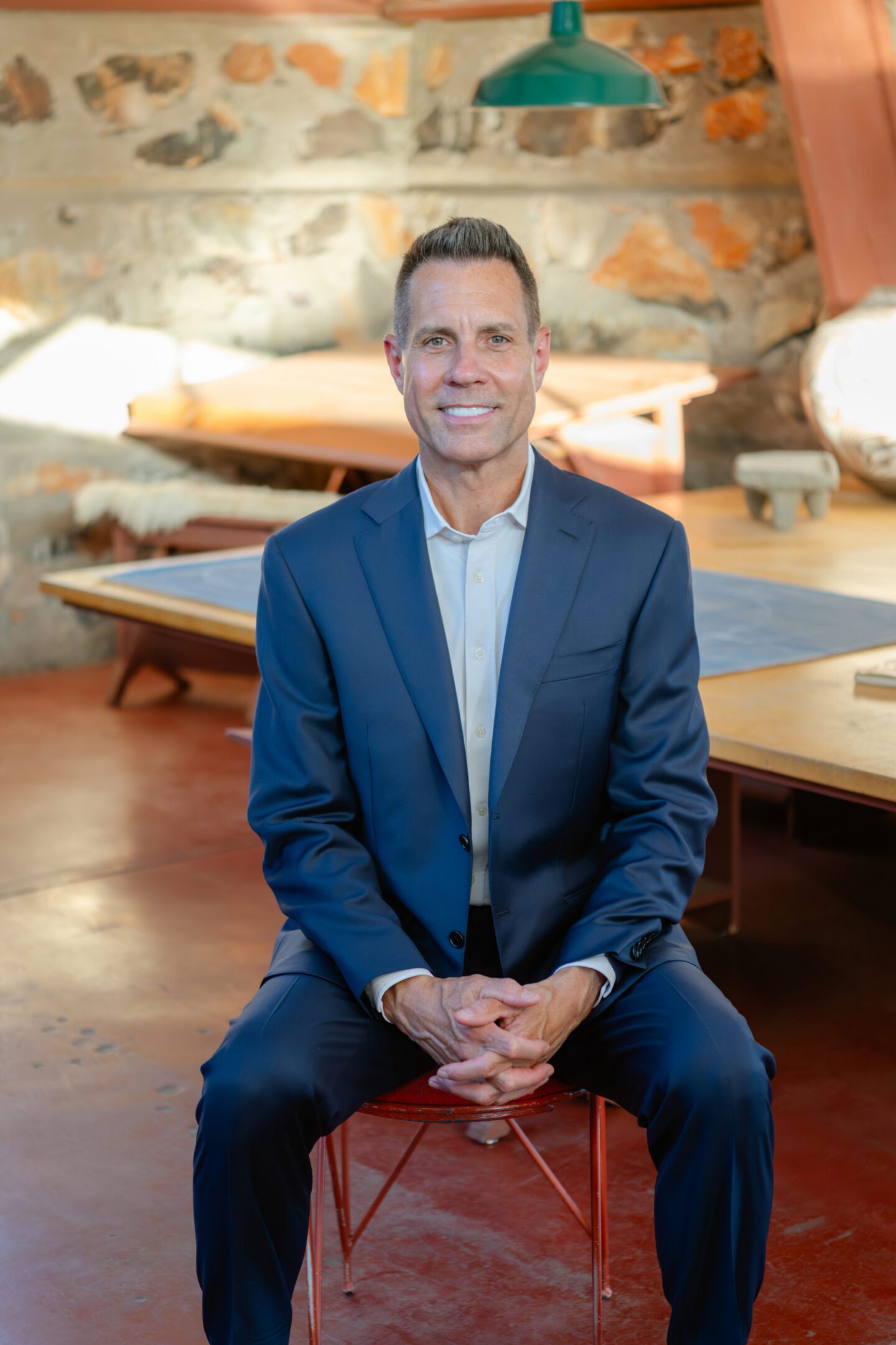 Smiling man in blue suit seated indoors