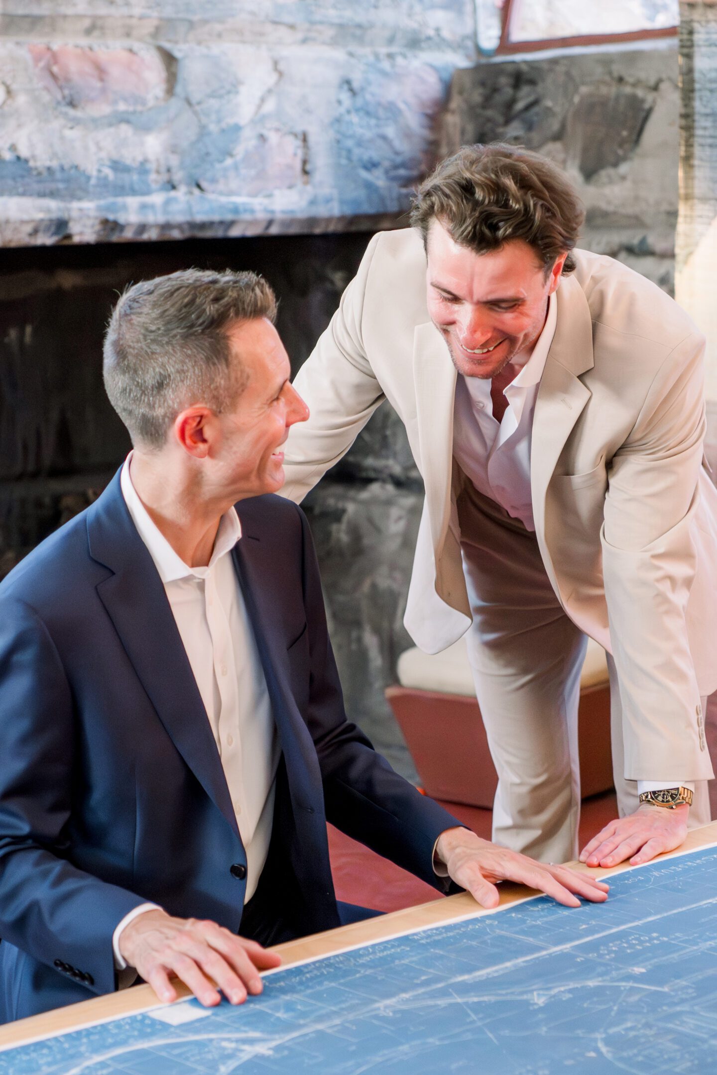 Two professionals examining blueprints at a table