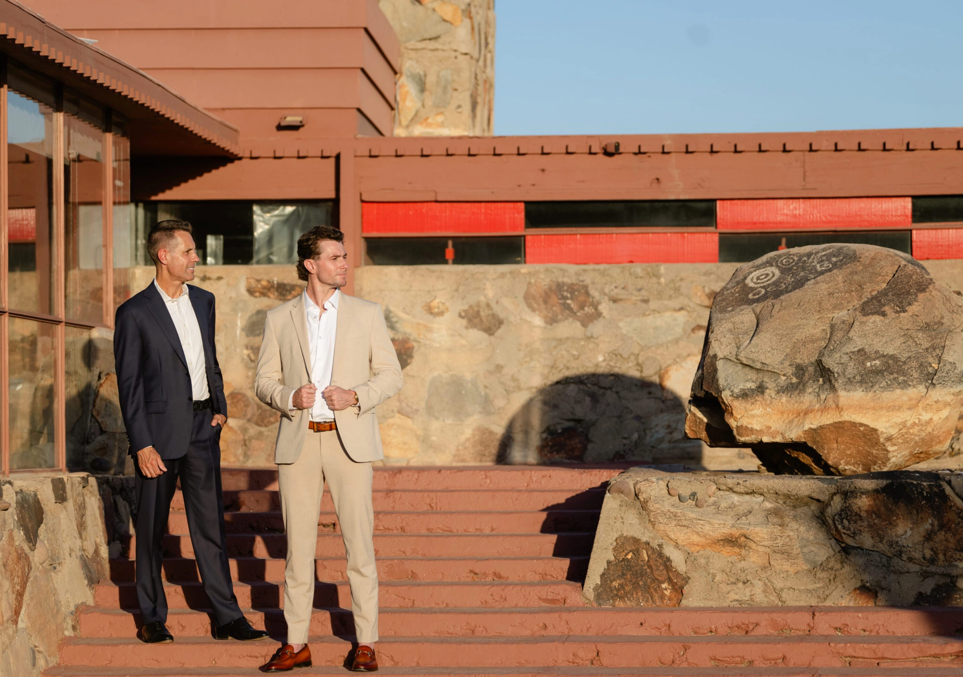 Two men in suits standing on stone steps