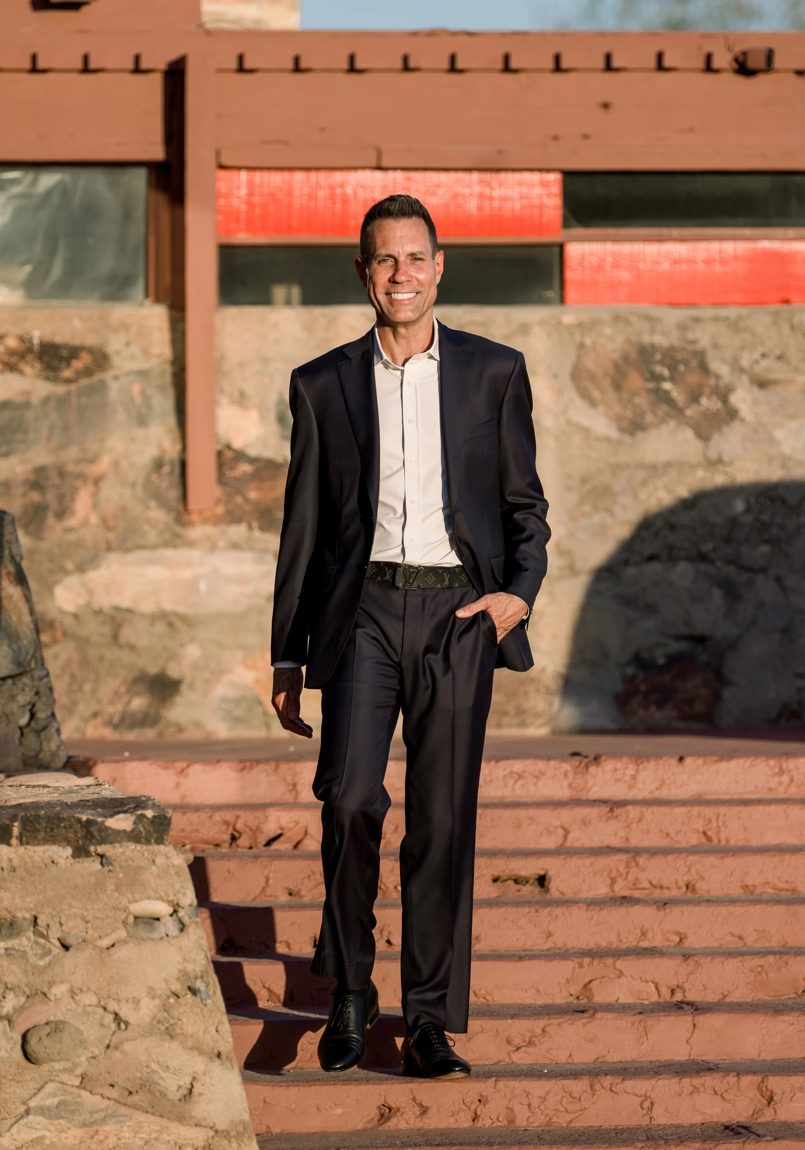 Smiling man in suit walking down outdoor steps