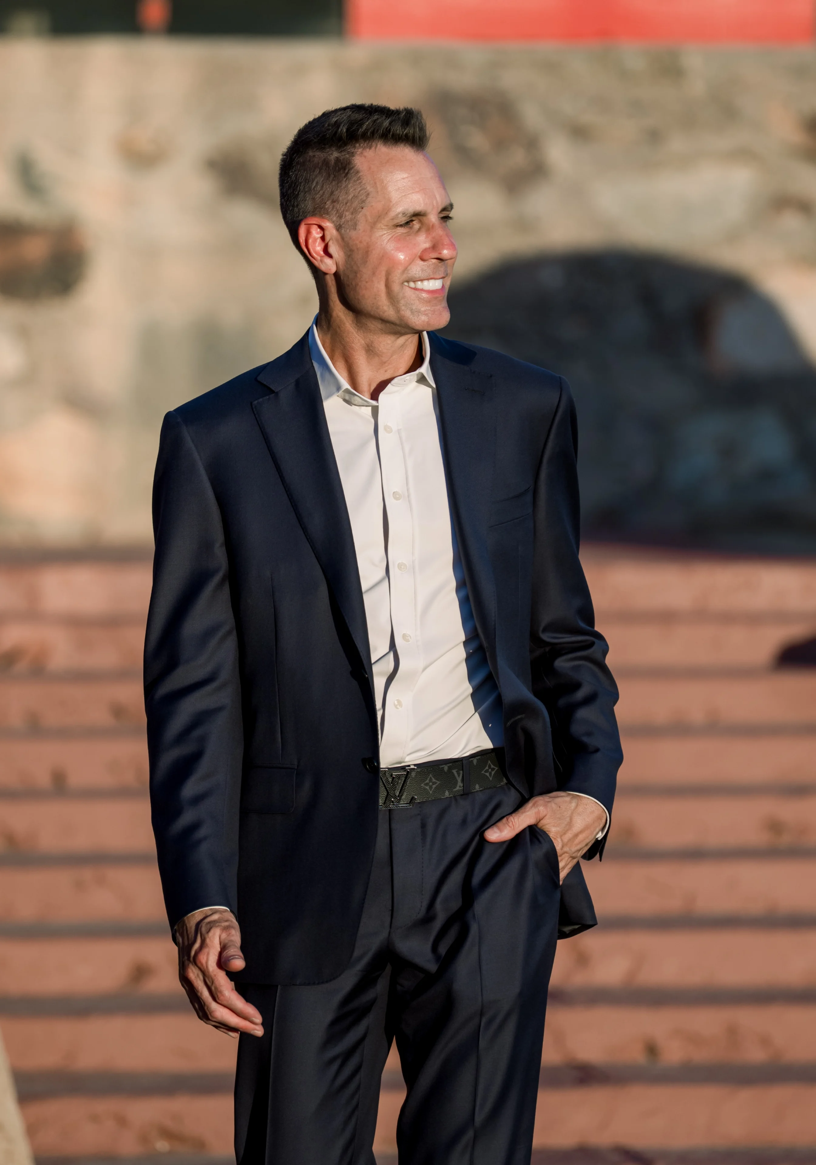Smiling man in navy suit on steps