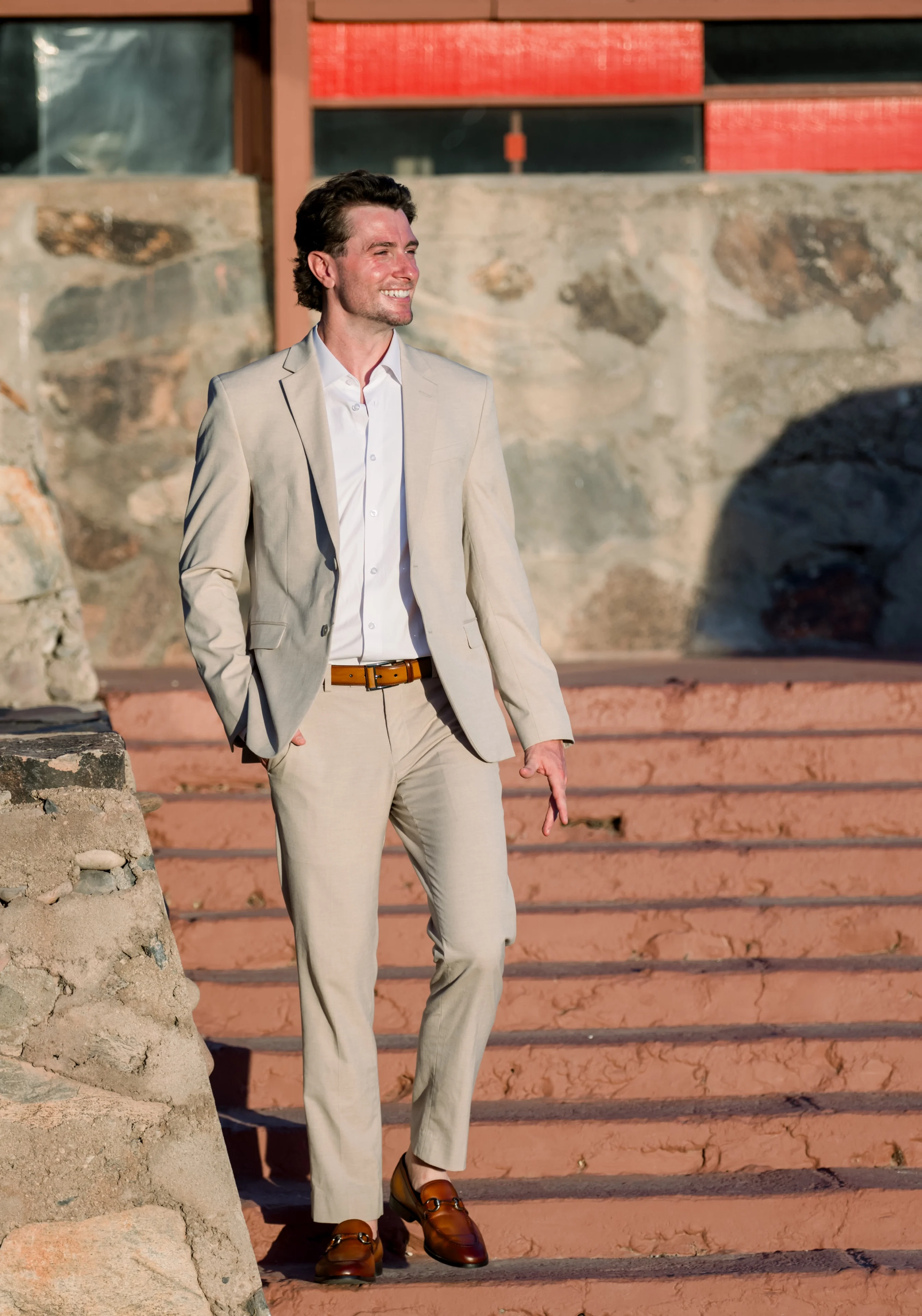 Smiling man in beige suit walking outdoors
