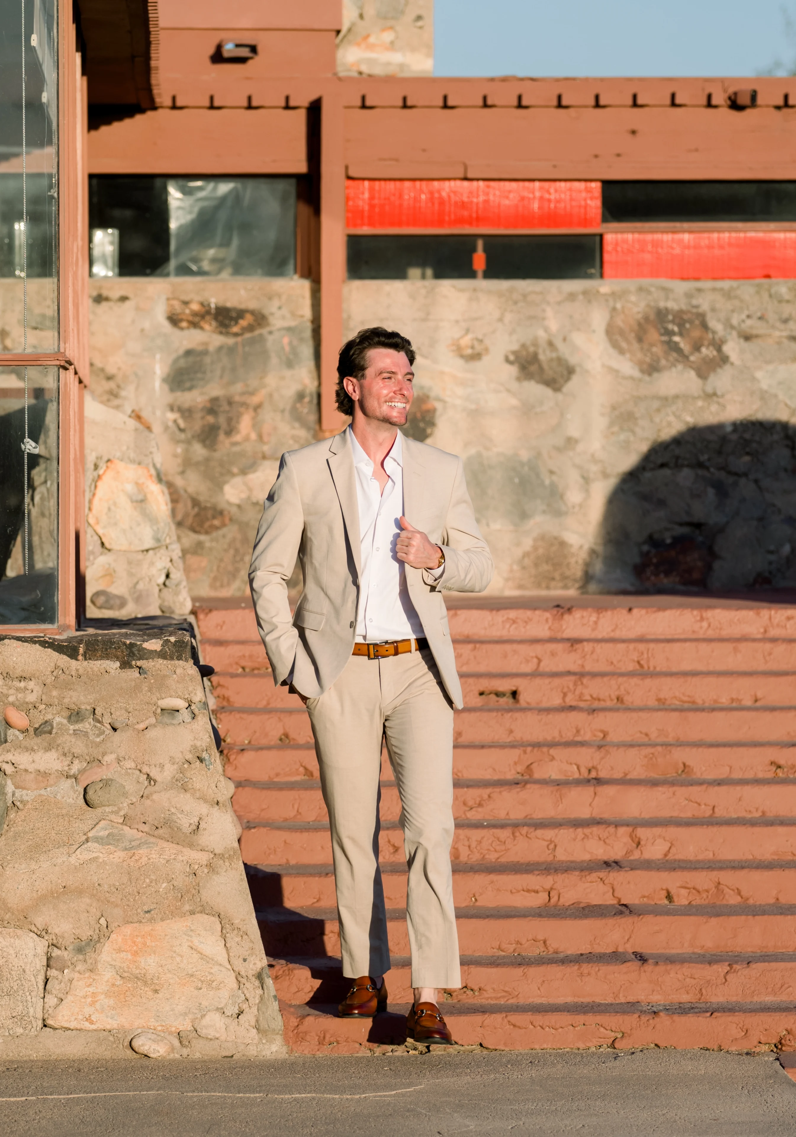 Smiling man in beige suit on steps